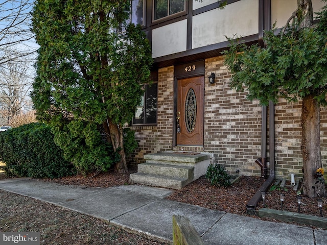 doorway to property with brick siding