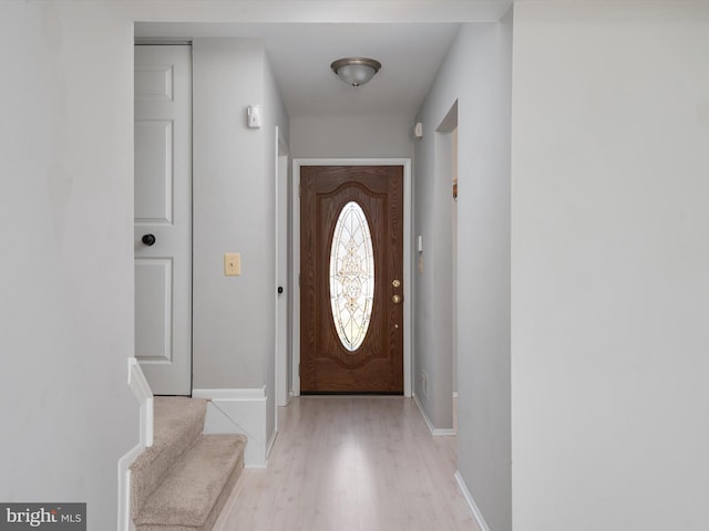 entryway with stairway, light wood-style flooring, and baseboards