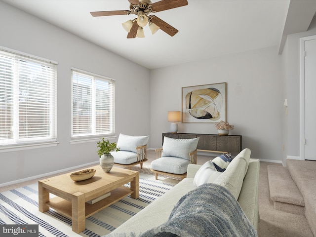 carpeted living room with ceiling fan and baseboards