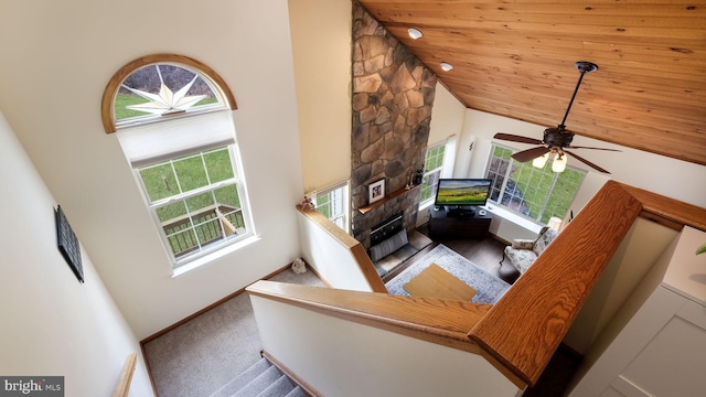 unfurnished living room with carpet floors, wooden ceiling, and high vaulted ceiling