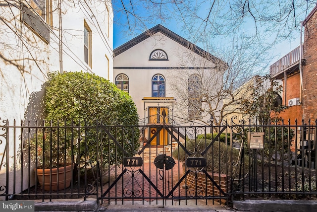 view of front of home with a fenced front yard, a gate, and stucco siding