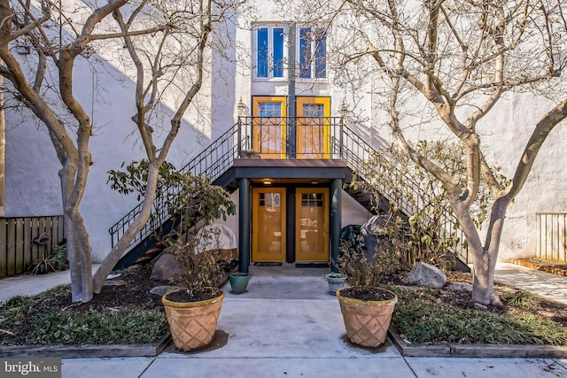 view of front of house with stairway and stucco siding