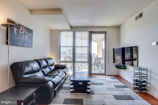 living room with wood-type flooring and a textured ceiling