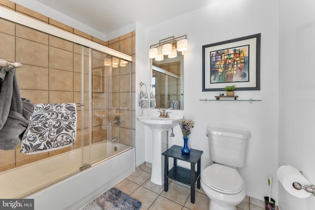 bathroom with enclosed tub / shower combo, toilet, and tile patterned floors