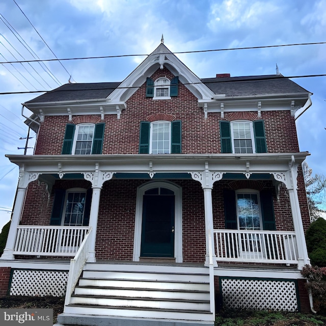 view of front of property featuring brick siding and a porch