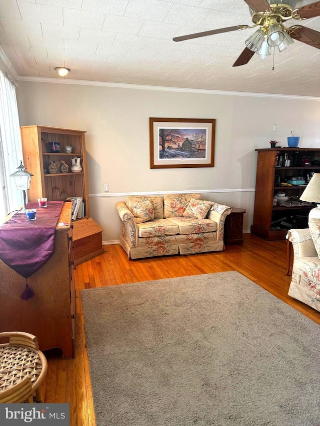 living room featuring ceiling fan, hardwood / wood-style flooring, crown molding, and a textured ceiling