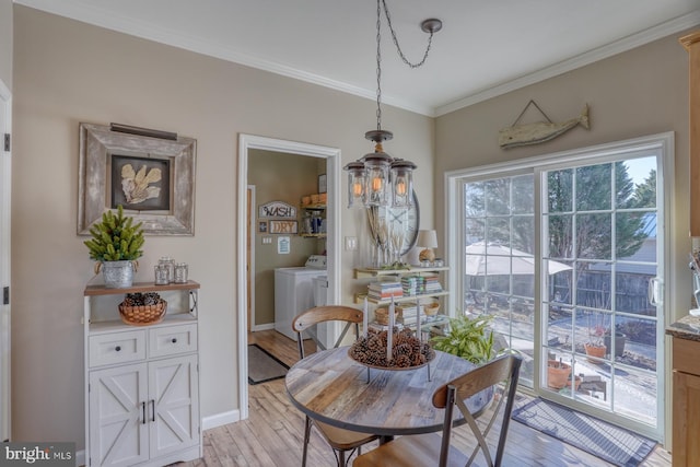 dining area featuring light hardwood / wood-style flooring, ornamental molding, and independent washer and dryer