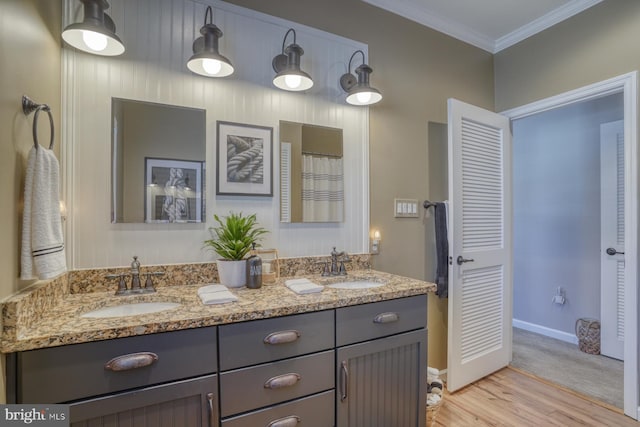 bathroom with crown molding, hardwood / wood-style floors, and vanity