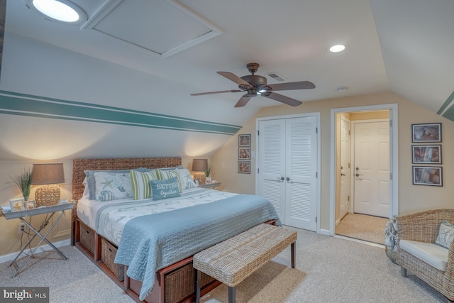 bedroom with vaulted ceiling, light colored carpet, ceiling fan, and a closet