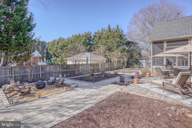 view of yard with a patio area, a sunroom, and an outdoor fire pit