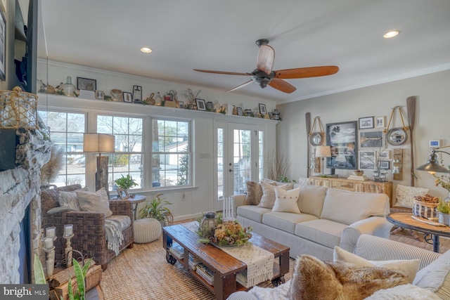 living room with a fireplace, crown molding, a wealth of natural light, and ceiling fan