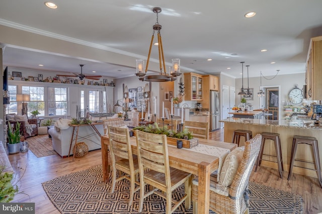 dining area featuring crown molding, ceiling fan, light hardwood / wood-style floors, and french doors