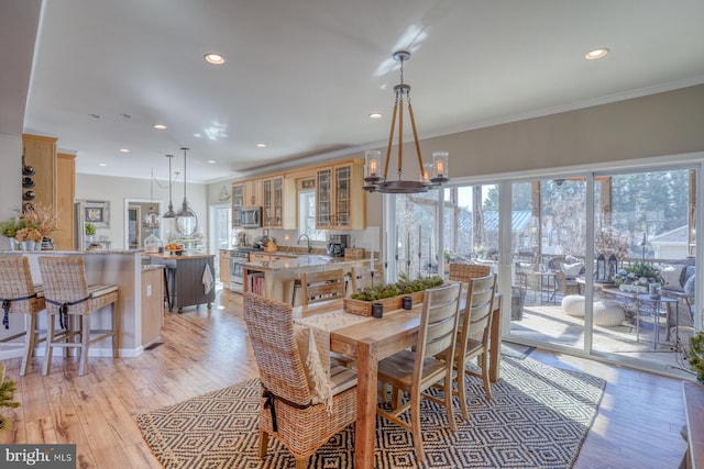 dining room with ornamental molding, plenty of natural light, and light wood-type flooring