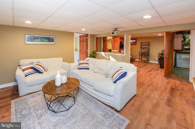 living room featuring a paneled ceiling and hardwood / wood-style floors