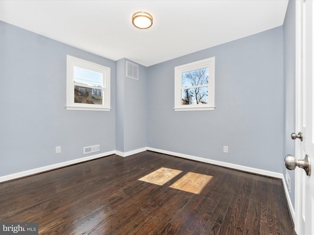 unfurnished room with dark wood-type flooring