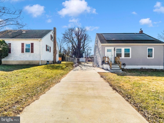 view of side of property with a yard and solar panels