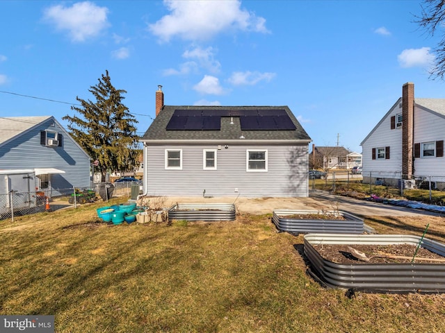 back of property with a yard, solar panels, and central AC unit