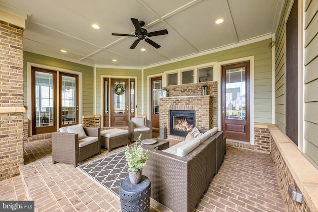 exterior space featuring brick floor, recessed lighting, crown molding, and an outdoor brick fireplace