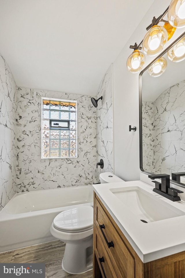 full bathroom with vanity, tiled shower / bath, hardwood / wood-style flooring, and toilet