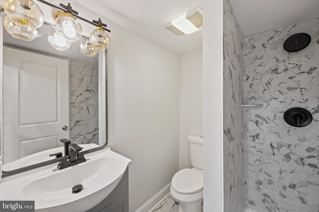 bathroom with vanity, toilet, and a tile shower