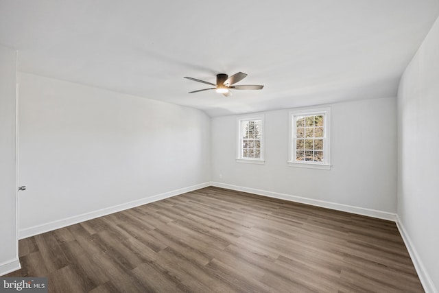 empty room with lofted ceiling, dark wood-type flooring, and ceiling fan