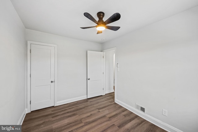 unfurnished bedroom with dark wood-type flooring and ceiling fan