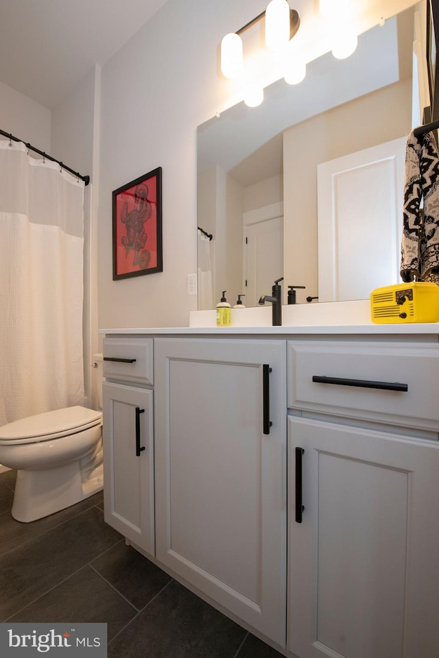 bathroom featuring vanity, tile patterned floors, and toilet