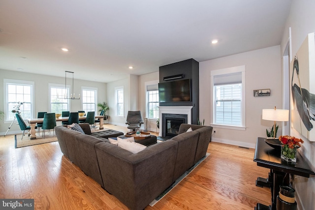 living room with a large fireplace and light wood-type flooring