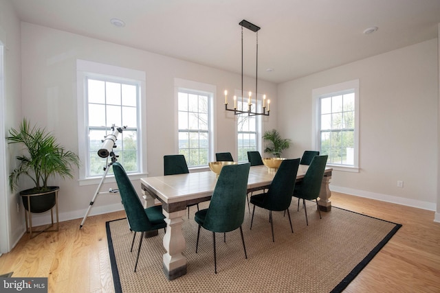 dining space with a chandelier and light wood-type flooring