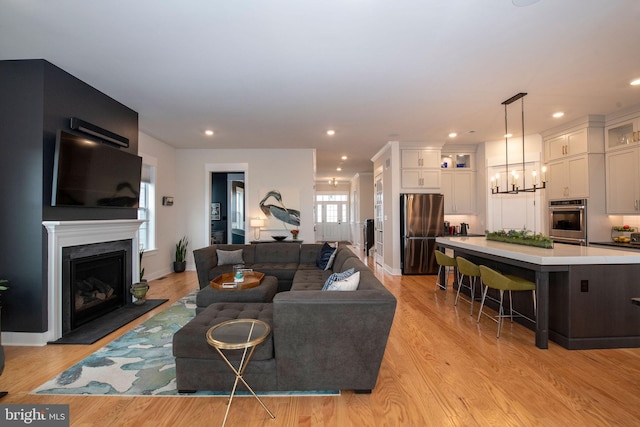 living room featuring light hardwood / wood-style flooring and a notable chandelier