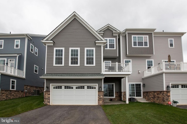 view of front of property featuring cooling unit, a garage, and a front yard