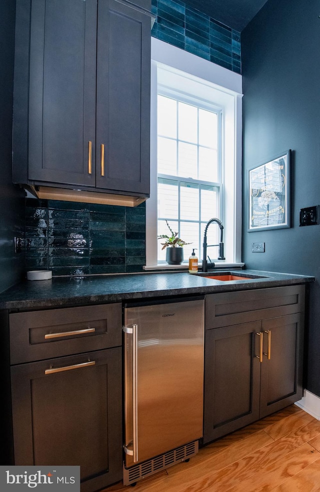 bar featuring dishwasher, sink, and backsplash