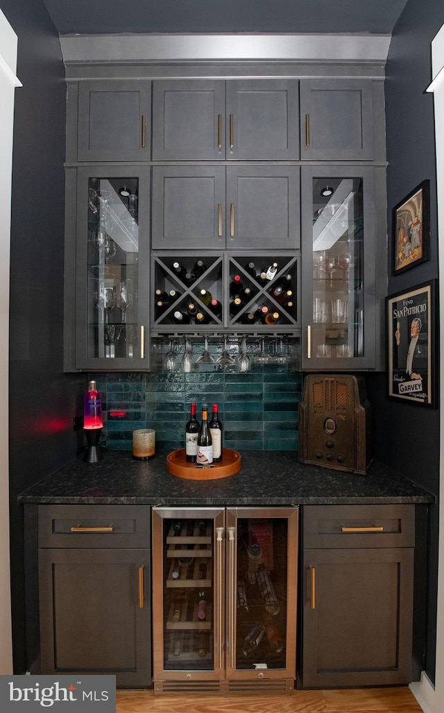 bar featuring gray cabinetry, wine cooler, and backsplash