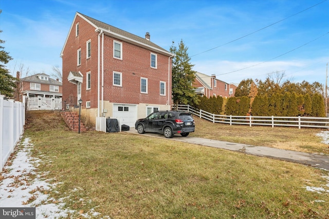 view of side of home featuring a garage and a lawn