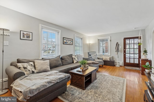 living room with light hardwood / wood-style flooring and a baseboard heating unit