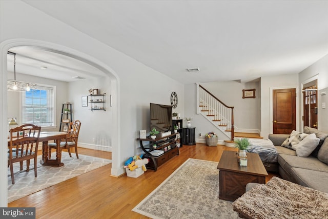 living room with an inviting chandelier and light hardwood / wood-style flooring