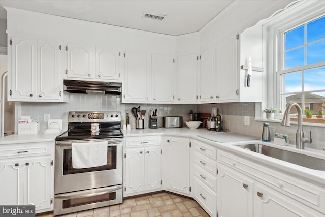 kitchen featuring white cabinets, tasteful backsplash, sink, and electric range