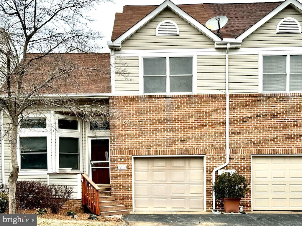 view of property with brick siding and an attached garage