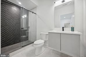 bathroom featuring tile patterned flooring, toilet, vanity, and walk in shower