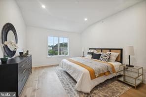 bedroom featuring vaulted ceiling and light hardwood / wood-style flooring