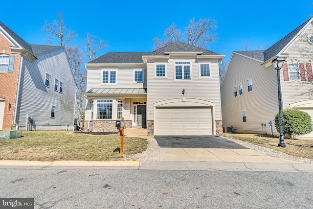 traditional-style home with a front yard, a standing seam roof, a garage, stone siding, and driveway