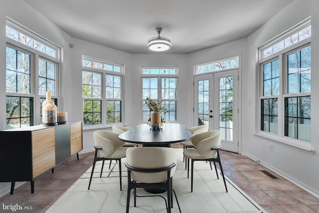 sunroom / solarium featuring french doors and a healthy amount of sunlight