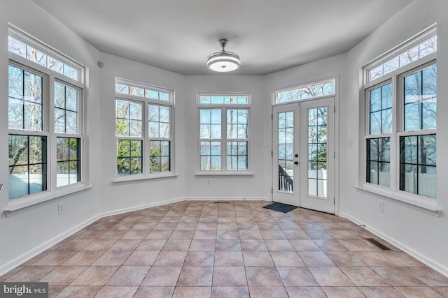 unfurnished sunroom featuring a healthy amount of sunlight and french doors