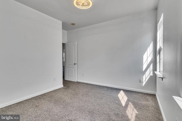 carpeted spare room with baseboards