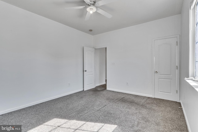 empty room featuring a ceiling fan, baseboards, and carpet flooring