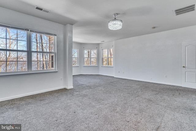 carpeted empty room featuring visible vents and baseboards