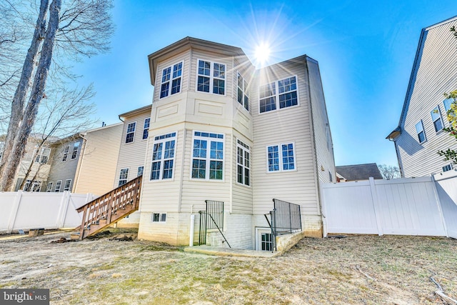 rear view of property featuring fence