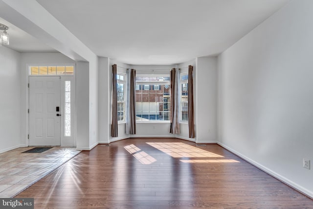 entrance foyer with baseboards and wood finished floors