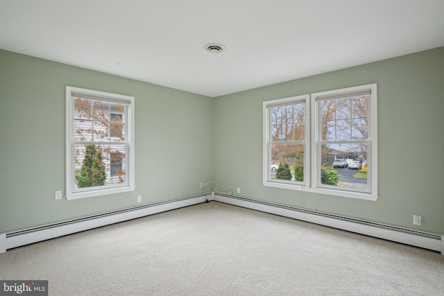 carpeted spare room featuring baseboard heating and visible vents