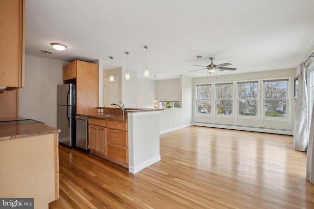 kitchen featuring a peninsula, baseboard heating, light wood-type flooring, a ceiling fan, and stainless steel appliances